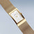 BERING Damenuhr mit rechteckigem Goldgehäuse, Milanaise-Armband und goldenem Sekundenzeiger