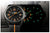 Herrklocka med svart urtavla och lysande markeringar i grönt/orange; svart textilarmband