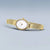Bering Damenuhr Gold mit weißem Zifferblatt und Milanaise-Armband, quer getragen