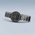 Damenarmbanduhr im offenen Blickwinkel mit schwarzem Zifferblatt und silbernem Metallarmband.