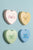 Fyra hjärtformade väggklocksdesigner i pastellfärger: XOXO, LOVE YOU, ONLY YOU, TOO CUTE