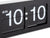 Svart flipklocka på väggen i närbild med visning 10:10