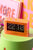Neonorange bordsklocka med transparent akrylhölje och bläddernummer, visar 22 och 10.