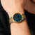 Bering Herrenarmbanduhr am Handgelenk mit grünem Zifferblatt und Gold-Silber-Armband