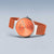 Analog klocka liggande: orange urtavla och orange milanesearmband
