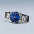 Herrenarmbanduhr am Handgelenk mit silbernem Metallband und blauem Zifferblatt