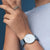 Herrenuhr am Handgelenk mit blauem Silikonband und weißem Zifferblatt