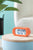 Orange digital väckarklocka med LCD-display 00:04 på träfot