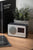 Svart FM-väckarklockradio med högtalare, display och antenn på träyta