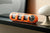Orange väggklocka på hylla med flip-display och analog urtavla