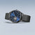 Herrenarmbanduhr mit blauem Zifferblatt, sichtbarem Automatikwerk und schwarzem Milanaise-Band