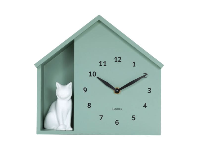 Huisvormig wandklok in mintgroen met zittende witte kat, cijfers 1-12 en zwarte wijzers