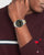 Tommy Hilfiger Herrenarmbanduhr am Handgelenk, schwarzes Zifferblatt, gold-silbernes Band