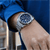 Herren-Armbanduhr am Handgelenk mit silbernem Band und dunkelblauem Chronograph