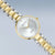 Damenarmbanduhr mit zweifarbigem Edelstahlband, rundem weißem Zifferblatt und goldener Lünette