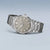 Herrenuhr in Seitenansicht, silbernes Edelstahlgehäuse und Metallarmband, graues Zifferblatt