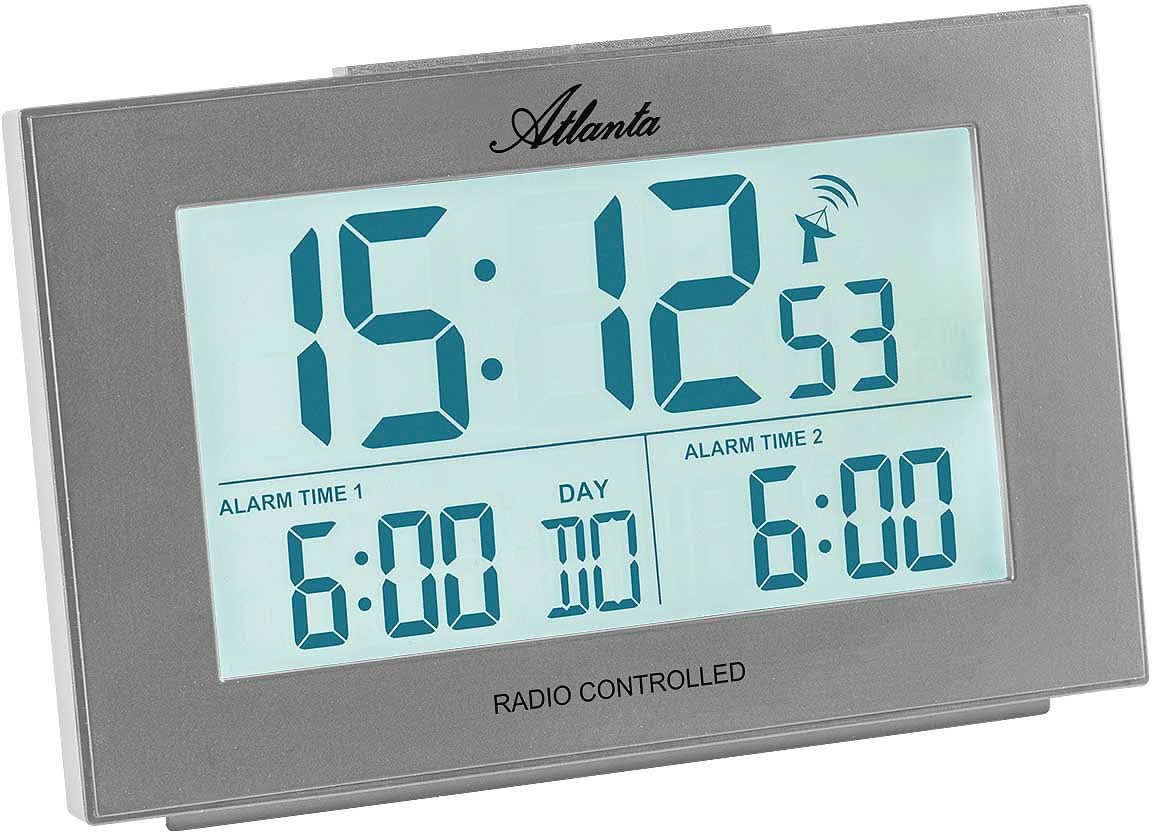 Digital radiostyrd väckarklocka med blå LCD-display, grått hölje och larmindikering