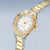 Damenuhr mit goldener Lünette, silbernem Metallarmband und weißem Zifferblatt