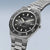 Herrenarmbanduhr im Detail: schwarzes Zifferblatt mit Indexen, Metallarmband