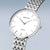 Damenuhr mit weißem Zifferblatt, silberfarbenem Gehäuse und Metallarmband
