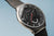Herrenarmbanduhr Nahansicht: schwarzes Zifferblatt mit Chronographenziffern und Milanaiseband