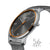 Herrenarmbanduhr, Seitenansicht: silbernes Gehäuse mit orangeem Ring und grauem Stoffband