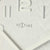 Detaljerad vy av väggklocka med NEXTIME-logotyp, visare och siffror