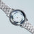 Silberne Damenarmbanduhr mit Metallgliederarmband und rundem Blüten-Zifferblatt in Perlmuttoptik