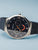 Bering Herrenuhr mit rundem Edelstahlgehäuse, blauem Zifferblatt und blauem Milanaiseband