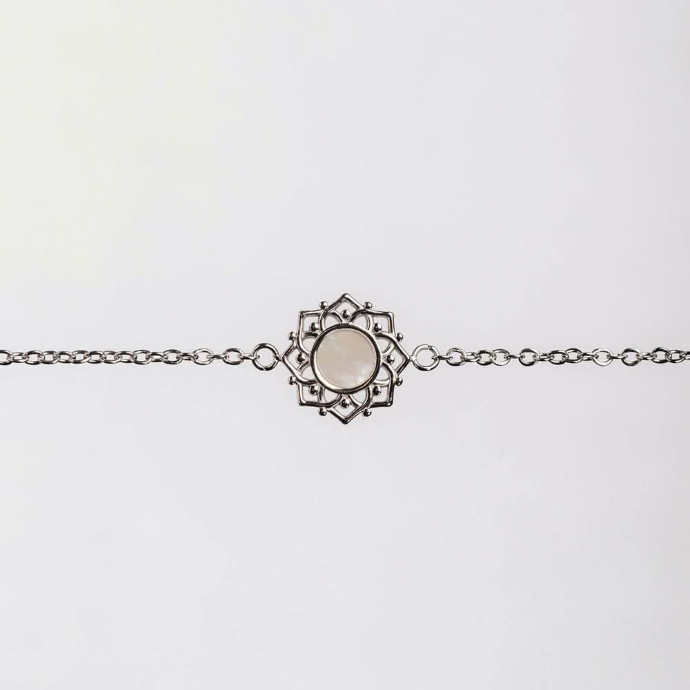 "Armband med silverfärgad länk och runt pärlemorhänge i ornamentram"