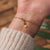 Fint armband med guldkedja och runt armbandslås på handleden