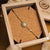 Armband i smyckeskrin: guldfärgat halsband med runt hänge med månsten