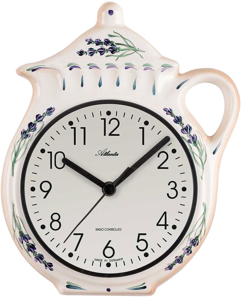 Väggklocka i keramik formad som en tekanna, vit med blå blommor, svart urtavla och handtag