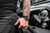 Herrklocka på handleden med svart urtavla, röda accenter och läderarmband