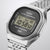Nahaufnahme: silberne Armbanduhr mit rundem Gehäuse und blauem Display