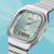 Casio Armbanduhr mit silbernem Metallarmband und hellgrünem Zifferblatt