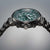 Herrenarmbanduhr Nahansicht: grünes Zifferblatt, schwarze Lünette und Drücker