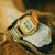 Casio G-Shock Armbanduhr mit goldfarbenem Edelstahlgehäuse, auf hellem Stein abgestellt
