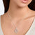 "Silver chain with round tree pendant worn close to the neck"