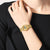 Casio damklocka med guldfärgat metallarmband och rund digital display på handleden