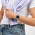 Armbanduhr am Handgelenk: blaues Armband, schwarzes Zifferblatt, transparentes Gehäuse