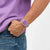 Swatch Armbanduhr am Handgelenk mit transparentem Gehäuse und violettem Zifferblatt