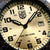 Närbild av urtavla: beige design, LUMINOX-logotyp, datum vid 3 och svarta visare
