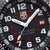 Luminox urtavla med LUMINOX-NOX-logotyp, röda index och datumfönster vid 3