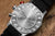 Baksidan på Vostok Europe herrarmbandsur med silverfärgat hölje och svart armband