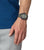G-Shock herrklocka på handleden, svart armband med gröna detaljer och rund display