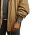 Herrklocka på handleden med svart armband och boett i silver under en jacka.