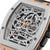 Nahaufnahme: Herrenuhr mit offenem Automatik-Mechanik-Zifferblatt, roségoldfarbenem Rahmen, schwarzem Band.