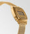 Damklocka med guldfärgat hölje och mesh-armband, sidovy med larm-/timerdisplay