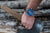 Herrklocka på handleden med blå urtavla och brunt armband.